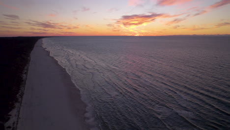 Luftaufnahme-Der-Ostsee-Bei-Goldenem-Sonnenuntergang-Und-Violettem-Himmel-In-Krynica-Morska,-Polen