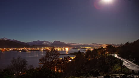 Time-lapse-of-Aalesund-Norwegian-city-illuminated-at-night-under-starry-sky-and-glowing-moon
