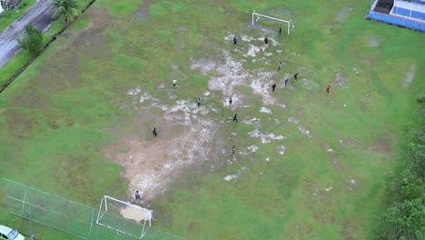 Slow-aerial-circling-over-group-of-friends-playing-soccer-on-grassy-field
