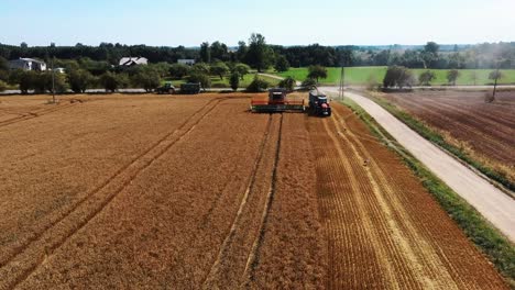 Aerial-Shot-of-Combine-Loading-Off-Corn-Grains-Into-Tractor-Trailer