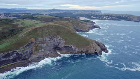 Drone-Captura-El-Paisaje-Verde-De-La-Isla-Junto-Con-El-Mar-Cantábrico-De-Color-Azul-Desde-Una-Gran-Altura