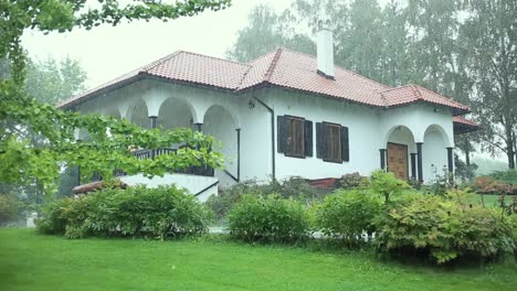 Rainy-day-in-countryside-with-big-rustic-house-in-beautiful-green-environment