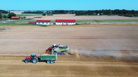Aerial-Shot-of-Combine-Loading-Off-Corn-Grains-Into-Tractor-Trailer-6