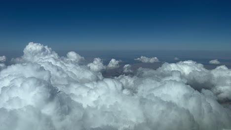 Aerial-view-from-a-jet-cockpit-overflying-some-tiny-cumulus-in-a-summer-afternnon