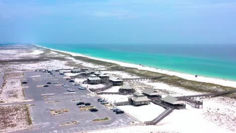 Drone-flying-over-the-public-beach-access-in-Navarre-FL-on-a-cloudy-day-but-with-beautiful-white-beaches-and-a-view-of-the-Gulf-of-Mexico