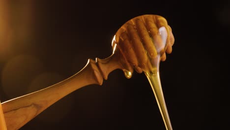 Static-shot-of-honey-spoon-in-evening-sun-with-delicious-vegetarian-honey-pouring-down