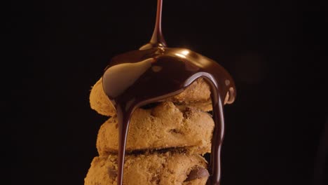 Static-shot-and-close-up-of-delicious-vegan-cookies-doused-with-vegan-chocolate-against-a-black-background