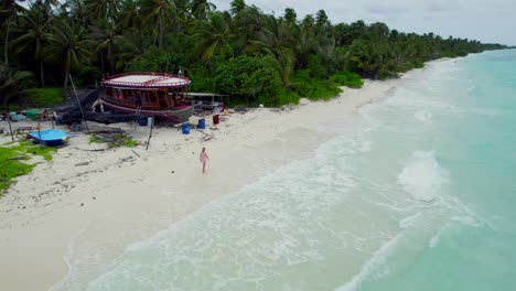 Junge-Frau,-Die-Friedlich-Durch-Die-Küste-Des-Tropischen-Strandes-Auf-Der-Insel-Dhigurah,-Malediven,-Geht