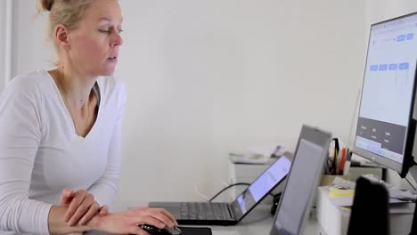 Woman-with-credit-card-in-office-paying-a-bill-typing-on-her-laptop-stock-footage