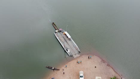 Aerial,-Docked-Barge-Attached-to-Canoe-Floating-on-Afram-River-Ghana-Africa