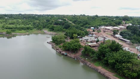 Umkreisende-Luftaufnahme-Eines-Kleinen-Fischerdorfes-Am-See-In-Ghana-Westafrika