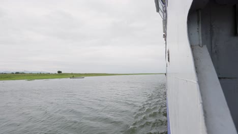 View-from-Moving-Vessel-on-Calm-River-with-Gentle-Waves-on-Cloudy-Day