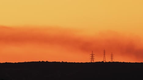 Misty-golden-dawn-with-smoke-over-electrical-towers