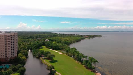 Drohnen-Luftaufnahme,-Die-An-Der-Eigentumswohnung-Mit-Einem-Wasserplatz-In-Destin-Florida-Neben-Der-Mid-Bay-Bridge-Vorbeifliegt