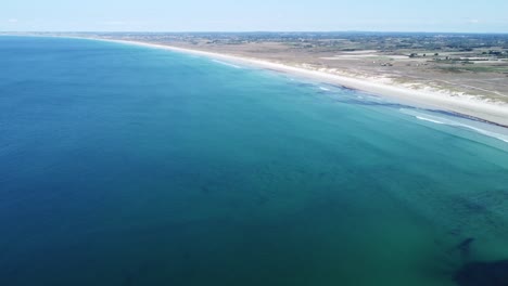 Endlessly-long-and-white-sandy-beach-near-la-torche-in-brittany-in-france,-filmed-with-a-drone-in-perfect-weather