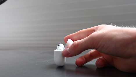 A-young-music-consumer-holds-in-his-hands-a-white-compact-box-designed-for-earphones