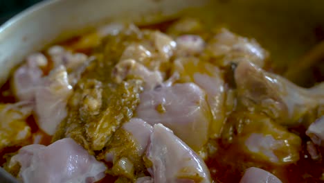 Raw-Poultry-Pieces-Being-Stirred-And-Cooked-In-Simmering-Curry-Sauce-In-Pot