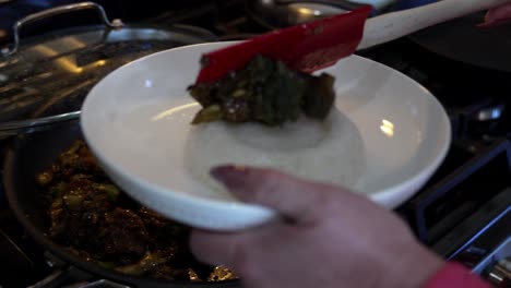 Dishing-up-a-plate-of-broccoli-and-beef-stir-fry-onto-a-bed-of-sticky-rice