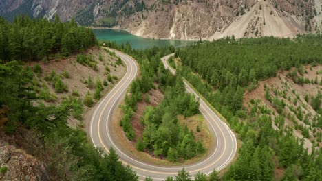Long-Winding-U-Shaped-Road-Slow-Aerial-Fly-Over-with-Mountain-and-River-View