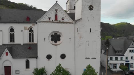 Aerial-pedestal-view-of-St-Castor-church,-located-in-Treis-Karden-in-Germany,-famous-touristic-destination-in-the-Mosel-Valley