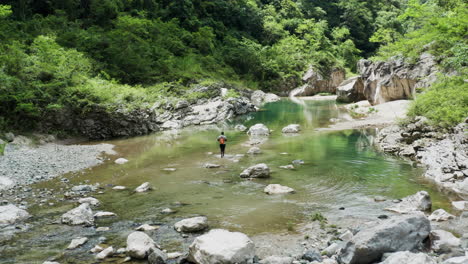 Shot-following-a-man-exploring-the-Nizao-river-in-tropical-rainforest-climate