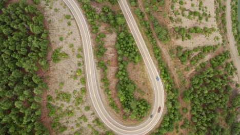 Long-Winding-U-Shaped-Road-Slow-Aerial-Rotational-Ascent---Moving-Traffic-Mountain-Forest-View-4K