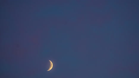 Timelapse-shot-of-beautiful-crescent-moon-moving-isolated-against-dark-black-sky-background-at-night-time