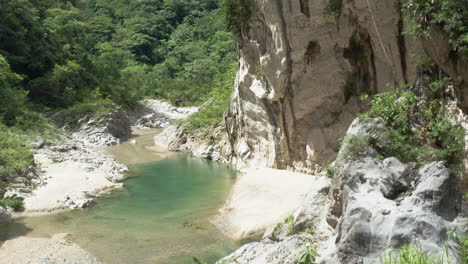 Drone-Ascending-Through-Rock-Formation-Reveal-Tranquil-Nizao-River-In-Dominican-Republic