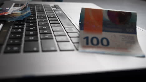 100-buck-bank-notes-on-a-laptop,-made-from-an-online-business-generating-cash