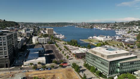 Aerial-shot-passing-through-South-Lake-Union-buildings-to-reveal-The-Center-for-Wooden-Boats-perched-on-Lake-Union