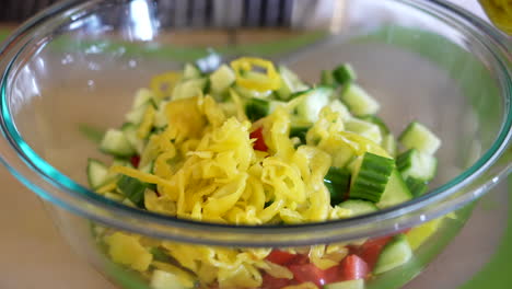 Adding-pickled-pepperoncini-to-a-bowl-of-chopped-salad-ingredients---ANTIPASTO-SALAD-SERIES