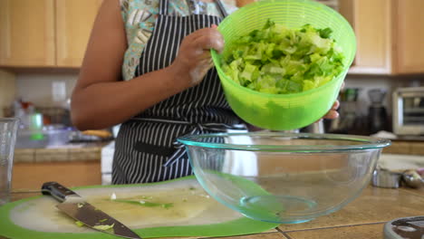 Dumping-chopped-romaine-lettuce-from-the-salad-spinner-into-a-bowl---ANTIPASTO-SALAD-SERIES