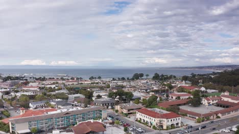 Wide-rising-aerial-shot-looking-out-at-Monterey-Bay-from-downtown-Monterey,-California