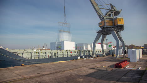Time-lapse-of-a-crane-loading-secured-containers-on-an-industrial-cargo-ship-berthed-at-the-port-at-day-time