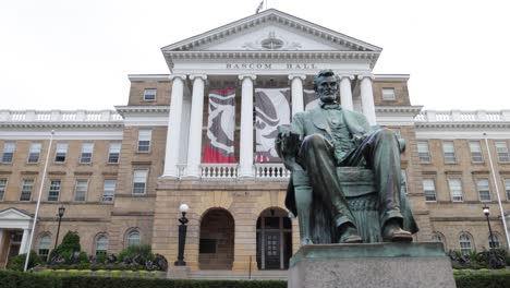 Abraham-Lincoln-statue-at-Bascom-Hall-at-the-University-of-Wisconsin-in-Madison,-Wisconsin-with-gimbal-video-walking-past