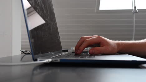 Ein-Laptop-Benutzer-Tippt-Auf-Der-Tastatur,-Arbeitet-Auf-Seinem-Schreibtisch,-Geldscheine-Fallen-Auf-Seine-Hände