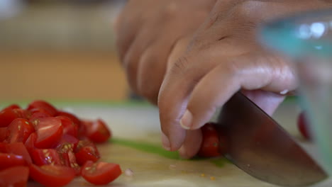 Focus-pull-to-reveal-the-hands-of-a-black-woman-cutting-cherry-tomatoes-for-a-chopped-salad---ANTIPASTO-SALAD-SERIES