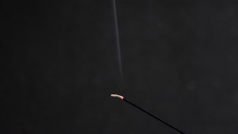 Incense-Smoke-Burning-Against-Dark-Background