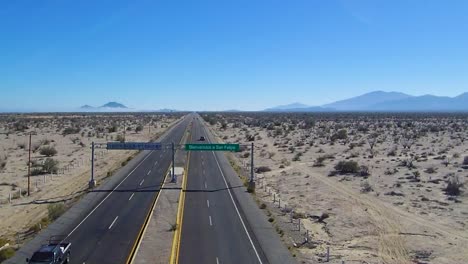 View-of-a-drone-descending-over-a-highway-showing-a-sign-that-says-"Bienvenidos-a-San-Felipe