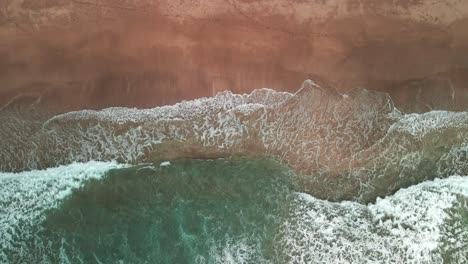 Drone-sitting-above-waves-on-the-shoreline