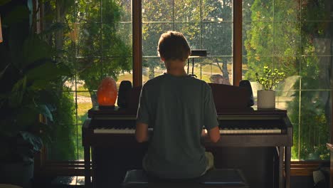 Boy-Playing-Piano-by-a-Window---wide-shot