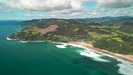 Drone-flying-along-beach-in-New-Zealand-with-mountains-in-the-background