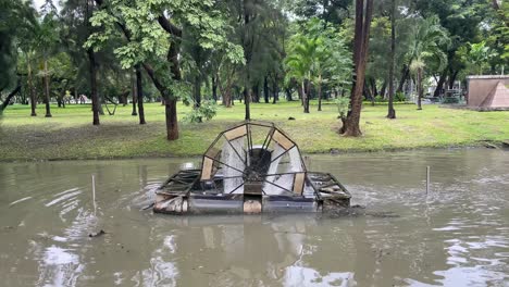 Aeration-turbine-wheel-oxygenating-the-waters-of-lake-in-Lumpini-Park,-Bangkok-,Thailand