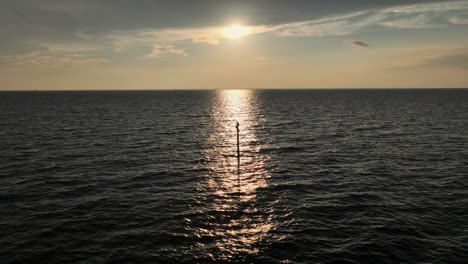 Sonnenuntergang-In-Der-Mobile-Bay,-Während-Ein-Pelikan-Auf-Einer-Stange-Thront