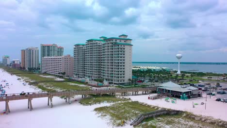 Drone-aerial-view-of-Navarre-Beach-FL-panning-left-to-show-the-Summerwind,-Navarre-Beach-Regency,-and-the-Pearl-resort