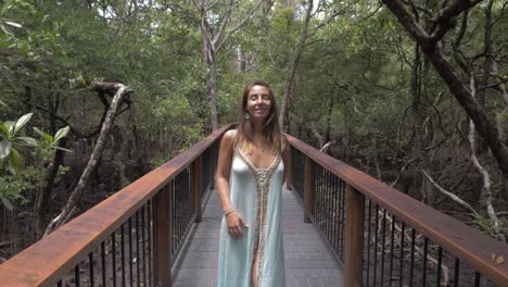 Lovely-Woman-In-Alluring-Dress-Look-Up-While-Standing-On-The-Bridge-At-Daintree-Rainforest-In-North-Queensland,-Australia