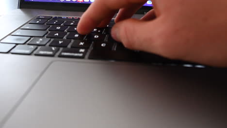 A-laptop-user-tries-to-find-a-key-on-his-keyboard,-computer-use,-message-and-typing