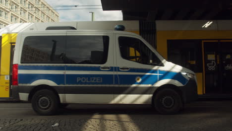 Urban-Tram-and-a-Police-Car-Drive-By-in-Berlin,-Germany