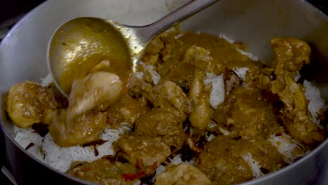 Fresh-Curry-Chicken-Being-Placed-On-Top-Of-White-Rice-In-Large-Pot