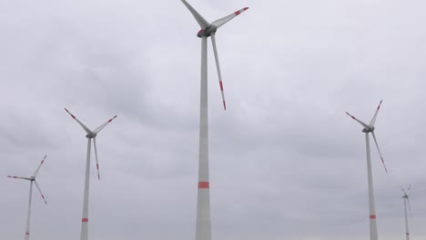 Verschiedene-Windmühlen-Im-Hintergrund-Mit-Dunklem-Bewölktem-Himmel